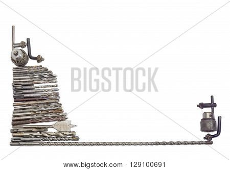 Several old drills and drill bits different sizes designs for different purposes with different shapes of shank and two chucks with keys on a light background