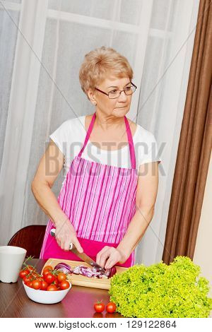 Woman cut red onion on cutting board