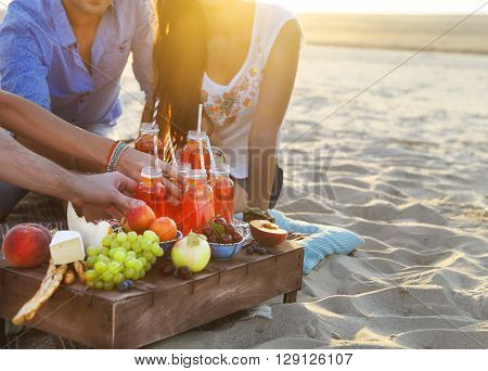 Group of friends holding drinks at the summer picnic. Close up