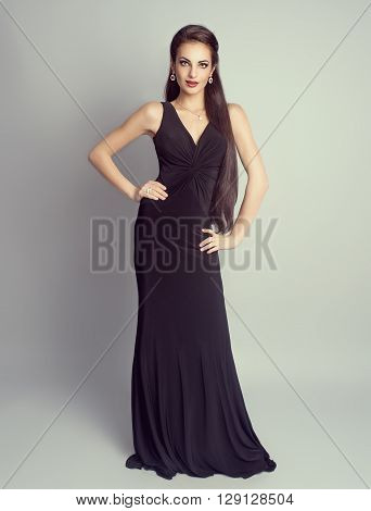 Rich brunette girl in luxury evening black dress in studio