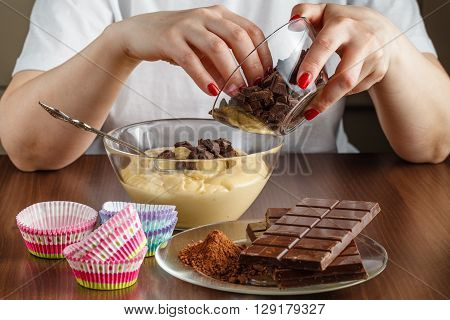 Woman made chocolade muffin on kitchen table