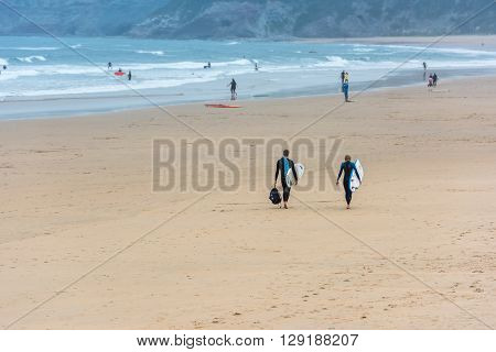 Surfers Walking Together Towards The Ocean