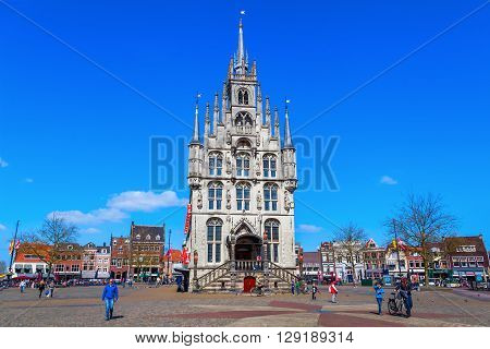Gouda Netherlands - April 20 2016: old city hall of Gouda with unidentified people. It was built between 1448 and 1450 and is one of the oldest Gothic city halls in the Netherlands