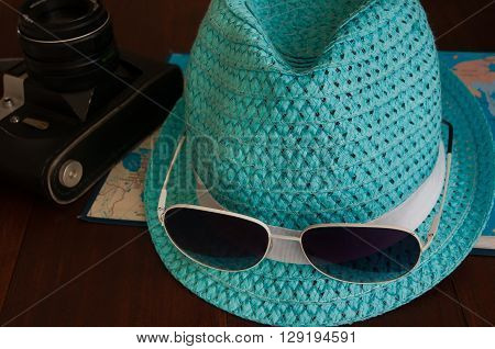 Preparation for traveltrip vacation tourism mock up of road map camerahat sunglasses on wooden table.