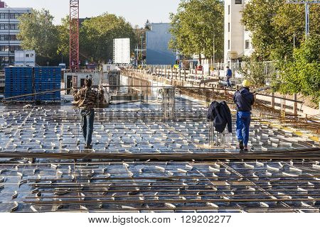HOFHEIM GERMANY - OCT 19 2009: workers assist the crane carrying building material to the construction site. Safety regulations at construction sites are very strict in Germany and controlled by officials.