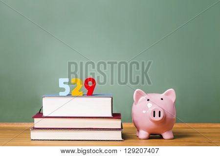 529 College Savings Plan Theme With Textbooks And Piggy Bank