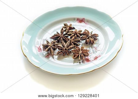 Anise stars heap on a stylish plate close up