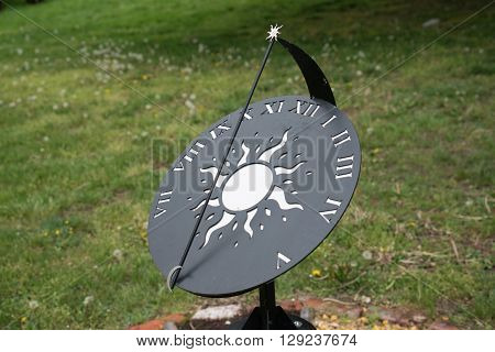 Modern blackand white sun dial in a garden