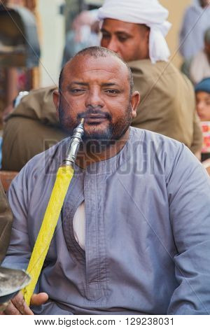 DARAW, EGYPT - FEBRUARY 6, 2016: Local man smoking shisha pipe at Daraw market.