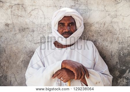 DARAW, EGYPT - FEBRUARY 6, 2016: Portrait of local camel salesman in white clothes and turban.