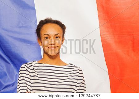 Portrait of beautiful African teenage girl in frock with French flag on background