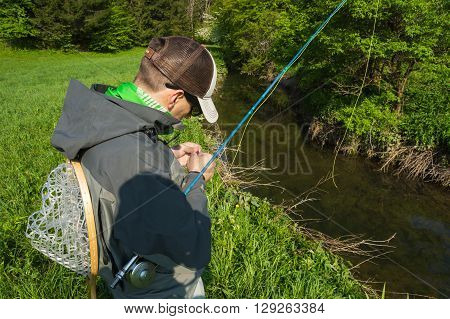 Fly fisherman chooses a fly for flyfishing trout