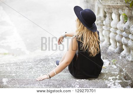 Beautiful hippie young woman wearing boho chic clothes and black hat outdoors