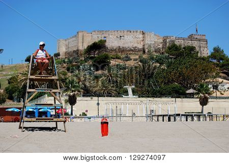 FUENGIROLA, SPAIN - JUNE 20, 2008 - Lifeguard on a wooden tower on the beach with Sohail castle to the rear Fuengirola Malaga Province Andalucia Spain Western Europe, June 20, 2008.