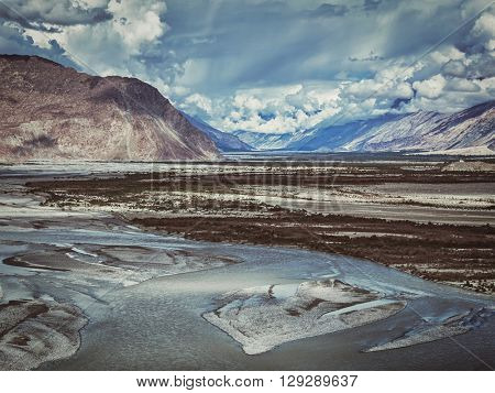 Vintage retro effect filtered hipster style image of Nubra valley and Nubra river in Himalayas. Ladakh, Jammu and Kashmir, India