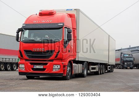 NAANTALI, FINLAND - APRIL 9, 2016: Red Iveco Stralis 460 Euro 6 and other cargo trucks on warehouse yard in South of Finland.