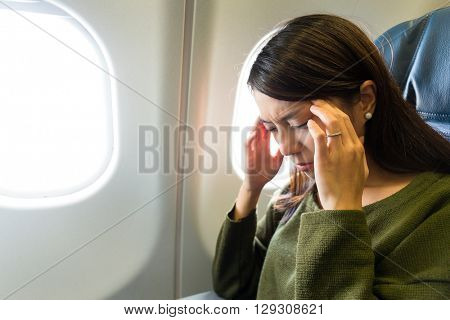 Woman in plane suffer from airsick with stress headache