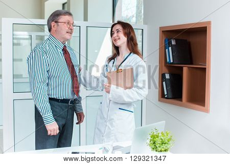 patient smiling to his doctor in medical office. Healthcare and support concept