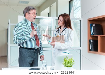 Young pretty woman doctor speaking with patient. Healthcare concept