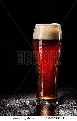 Beer Glass With Drops On Black. Fresh! Much Foam! Beer Bubbles Closeup. Draft. Overflow Beer Glass.