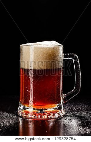 Beer Glass With Drops On Black. Fresh! Much Foam! Beer Bubbles Closeup. Draft. Overflow Beer Glass.