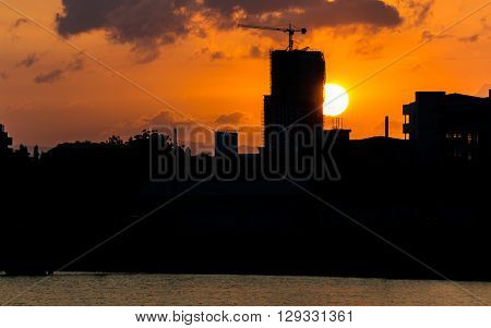 The Sunset behind a building under construction.