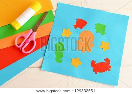 Paper applique with sea animals and fishes. Art lesson in kindergarten. Paper sea animals - octopus, fish, starfish, seahorse, crab. Kids crafts. Sheets of colored paper, scissors, glue