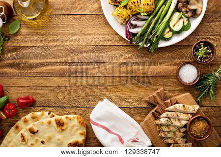 Grilled vegetables and chicken on wooden table overhead shot