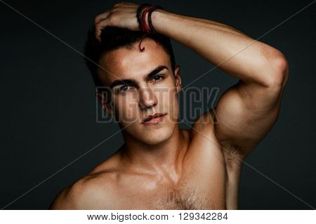 Fashion man portrait with his hand in his hair on dark background