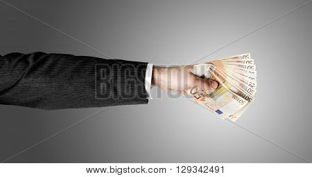 Businessman's hand holding a stack of fifty euro notes isolated on white background.