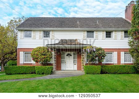 Luxury brick house with beautiful landscaping. Home exterior.
