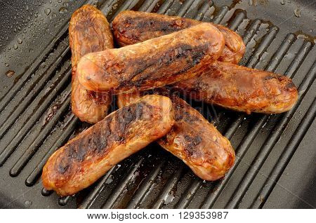 Freshly cooked pork sausages in a non stick griddle frying pan