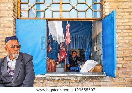 Buckara Uzbekistan - Aprilr 16 2014: Local people and vendors in the market on the side of the Kalon mosque