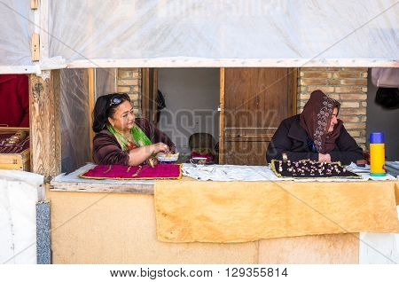 Buckara Uzbekistan - Aprilr 16 2014: Local vendors in the market on the side of the Kalon mosque