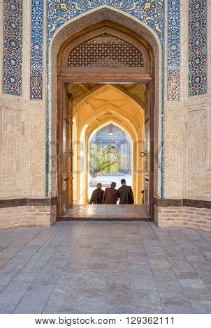 Buckara Uzbekistan - Aprilr 16 2014: Local people at the main entrance of the Kalon mosque