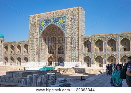 Samarkand Uzbekistan - April 18 2014: People in Registan square with the Tilla Kari madrassah in the background