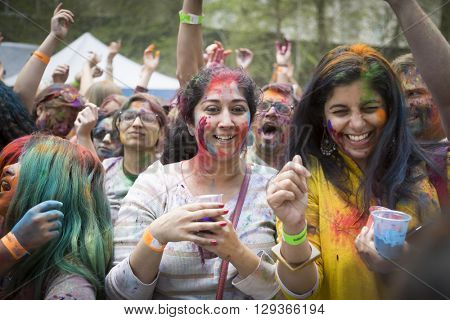 NEW YORK - APR 30 2016: A large crowd with colorful powder on their faces celebrate Holi Hai Festival of Colors and watch performers on the stage hosted by NYC Bhangra in New York on April 30 2016.
