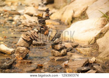 Zen tower bridge of different coloured stones in a shallow stream
