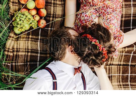 Beautiful Happy Bride And Stylish Retro Groom Lying On Tweed Blanket, Cuddling And  Relaxing, Picnic