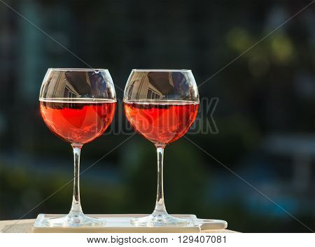 Two glasseses of rose wine, dark green bavkground