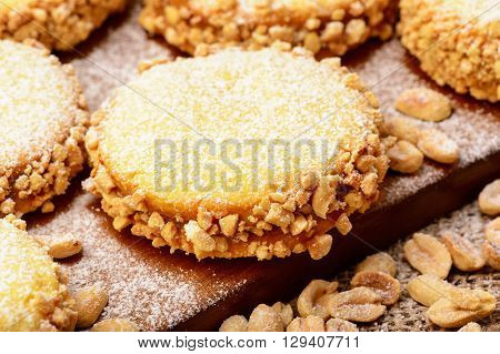 Butter cookies (alfajores) with caramel and peanut on wooden background.