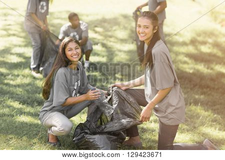 Team of young volunteers picking up litter in the park