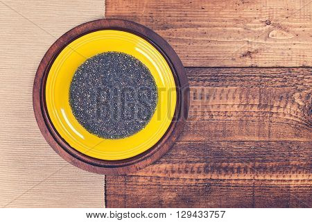 Chia jelly in yellow plate on grunge wooden background. Toned.