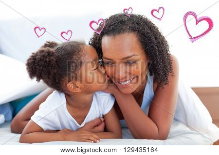 Red Hearts against cute little girl woman kissing her mother lying down on bed