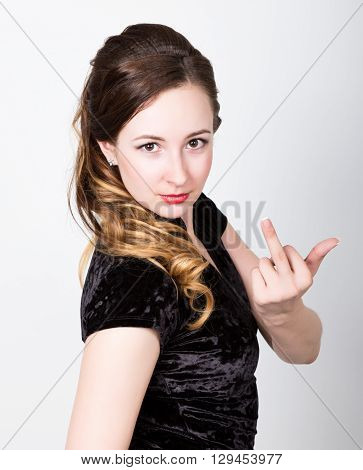 young woman's portrait with different happy emotions. she showing middle finger, provocative gesture.