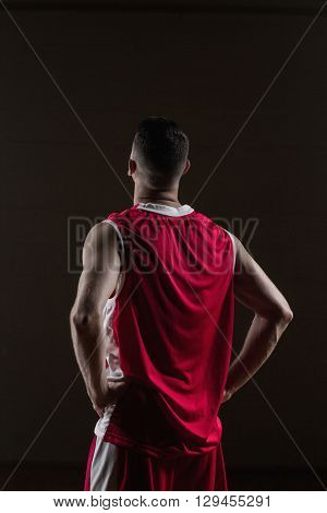 Portrait of basketball player front the back posing on a gym