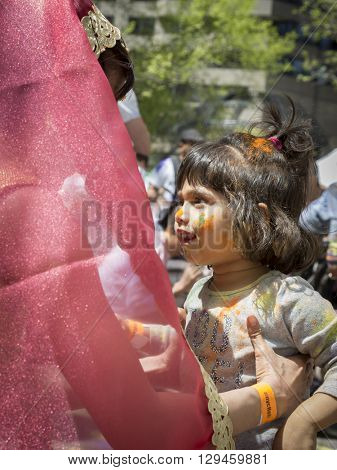 NEW YORK - APR 30 2016: A female member from NYC Bhangra dances with a little girl in the crowd at the Holi Hai Festival of Colors in Dag Hammerskjold Plaza in New York April 30, 2016.