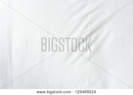 Top view of wrinkles on an unmade bed sheet after a long night sleep and waking up in the morning.