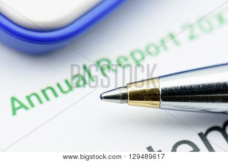 Blue ballpoint pen on an enterprise's annual report on a table waiting for an inspector to inspect before submission to the Chief Financial Officer (CFO). Financial investment analysis concept.