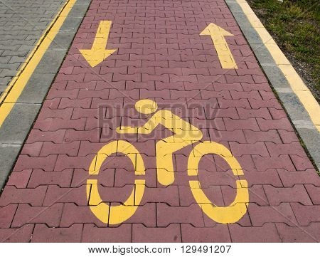 A bike lane or bike way symbol on asphalt roadway.